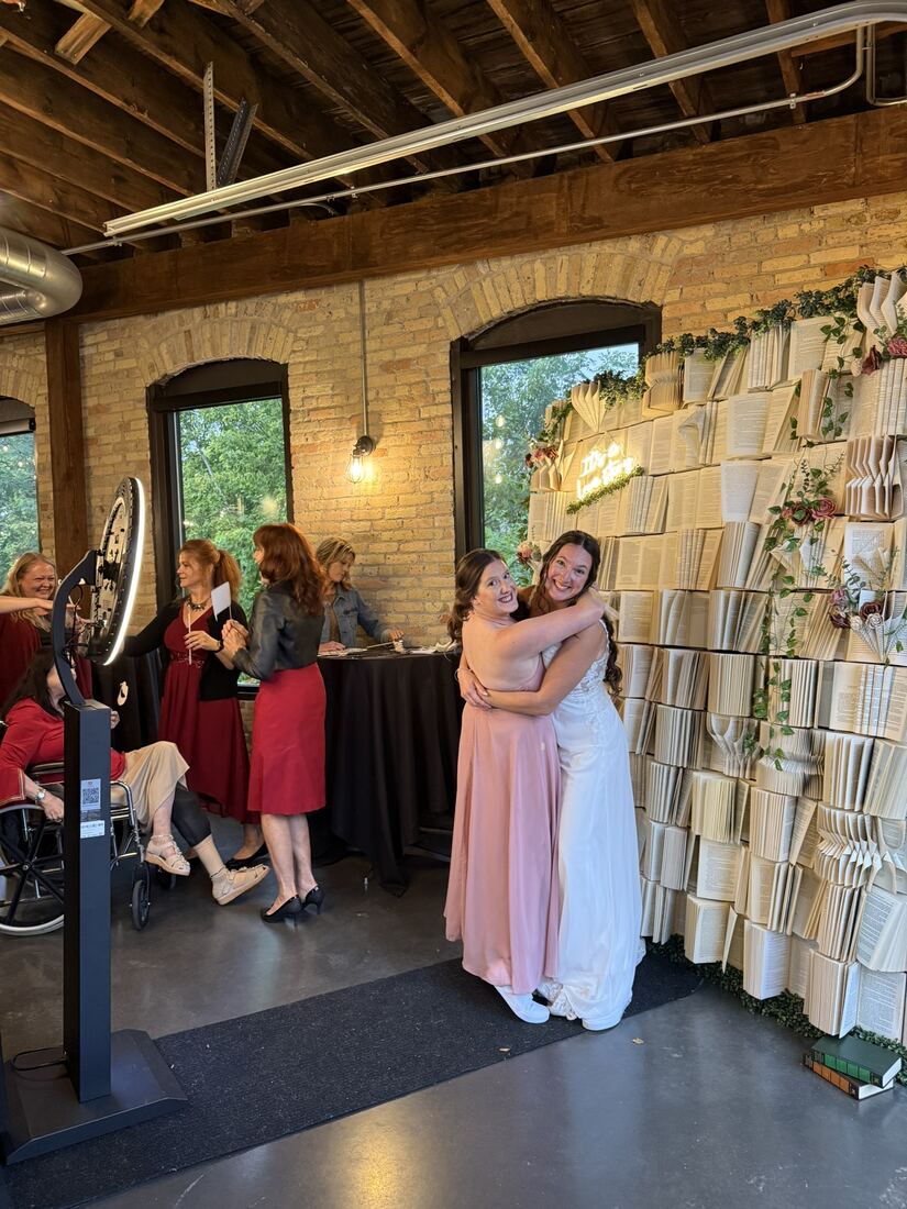 Bride hugging a guest at the selfie station